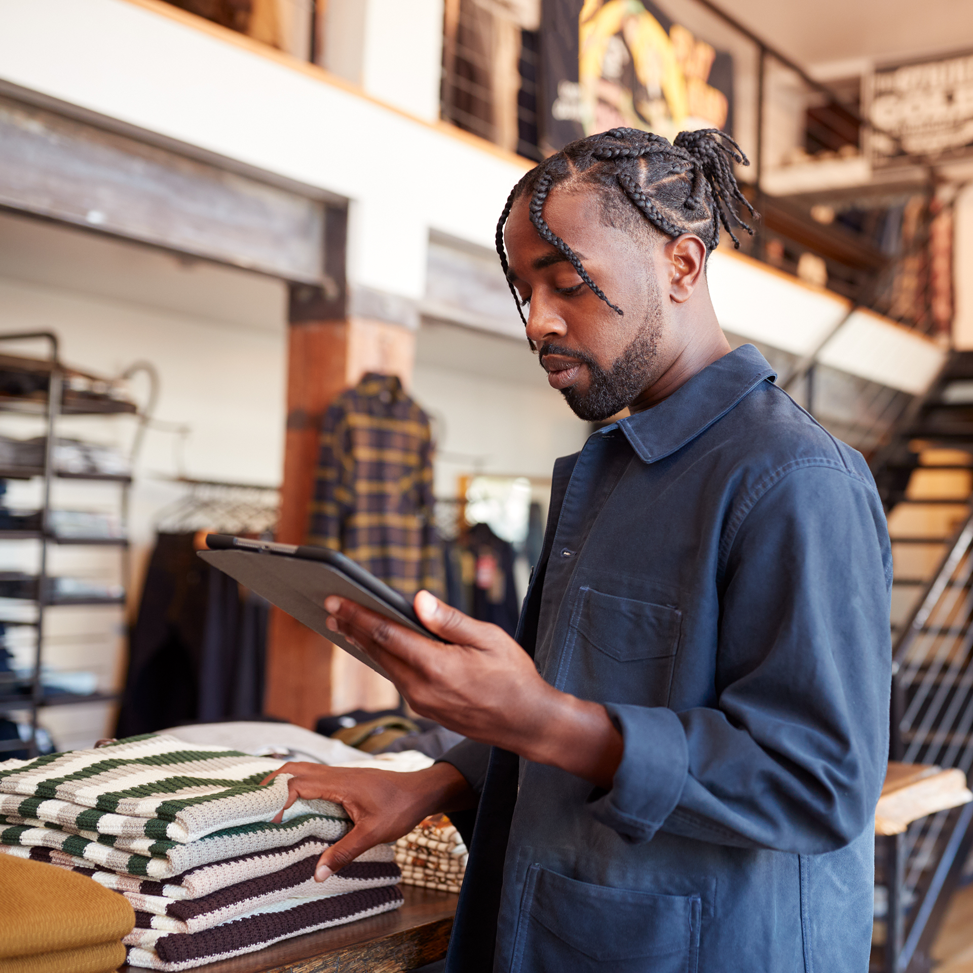 A man in retail holding a tablet