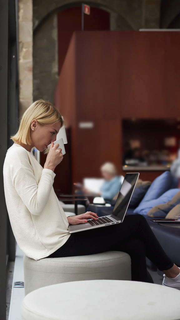 A woman drinking coffee and enjoying guest WiFi