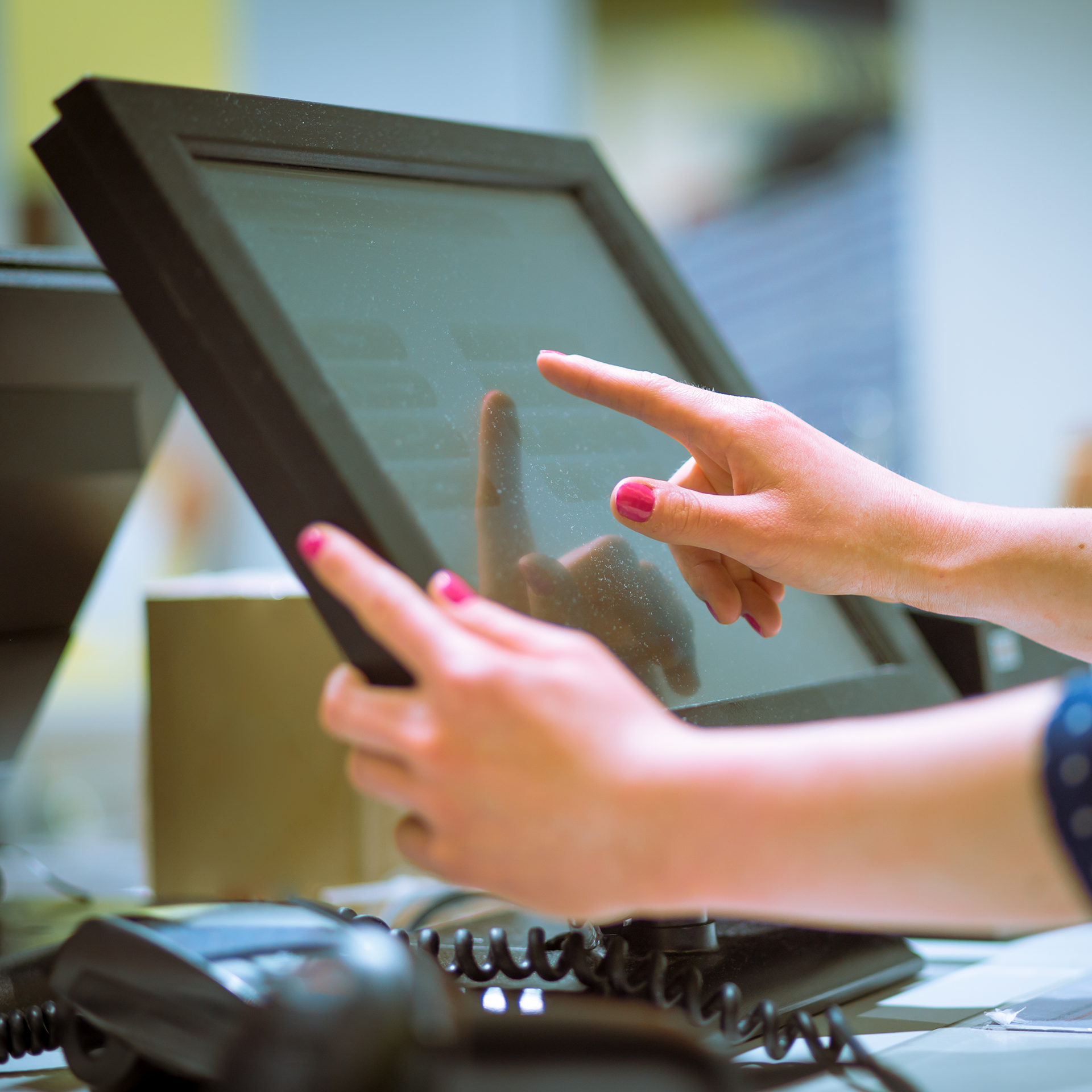 A woman using an EPOS system in the hospitality sector