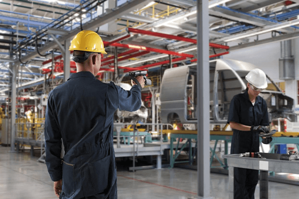 Man in a hard-hat scanning parts with an RFID scanner