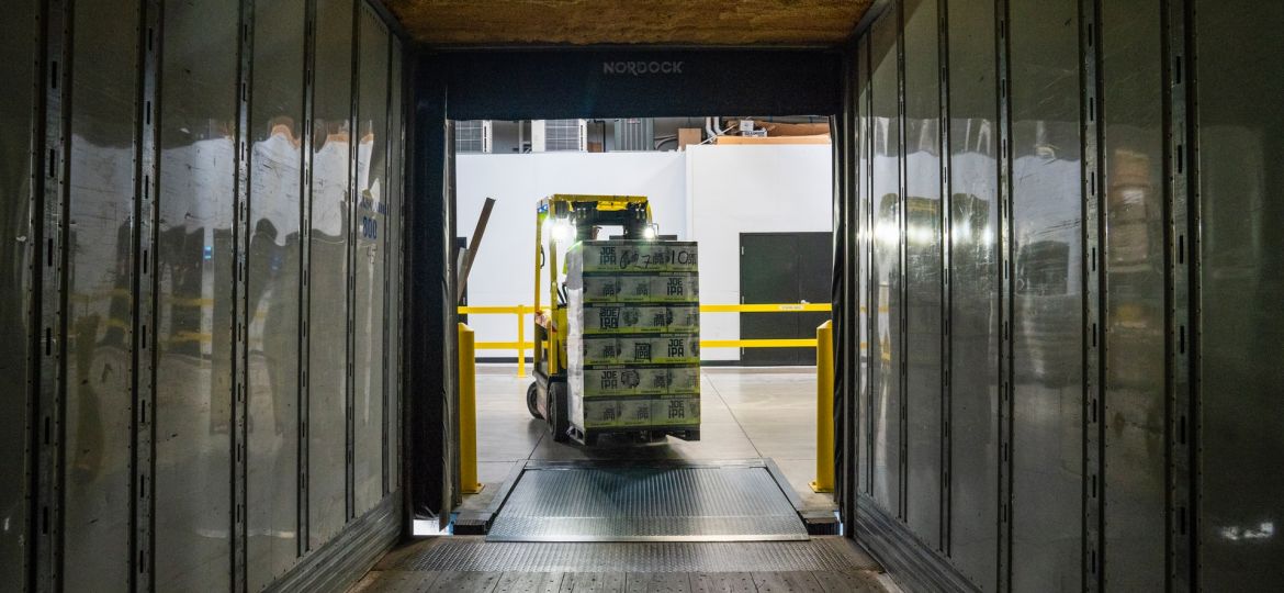 A forklift carrying a pallet of goods into a truck