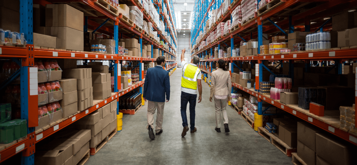 Two men and a woman walking through a warehouse